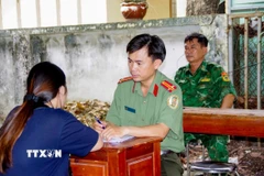Công an Tây Ninh làm việc với các công dân từ Campuchia về nước. (Ảnh: TTXVN phát) 